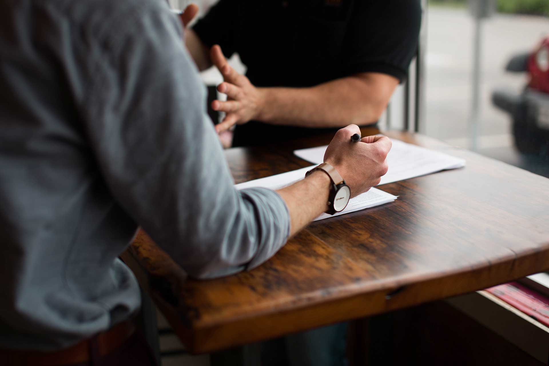 men sitting at a table writing notes